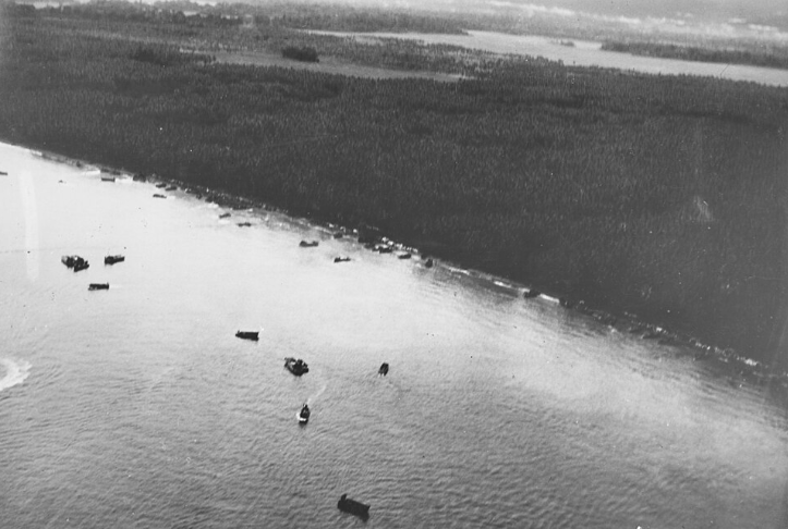 United States Marines disembark from landing craft and wade through the surf during an amphibious assault at Guadalcanal in August 1942.