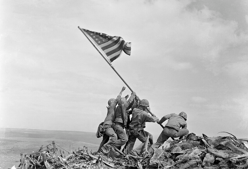 United States Marines raise the American flag over Mount Suribachi during the intense fighting for the island of Iwo Jima.
